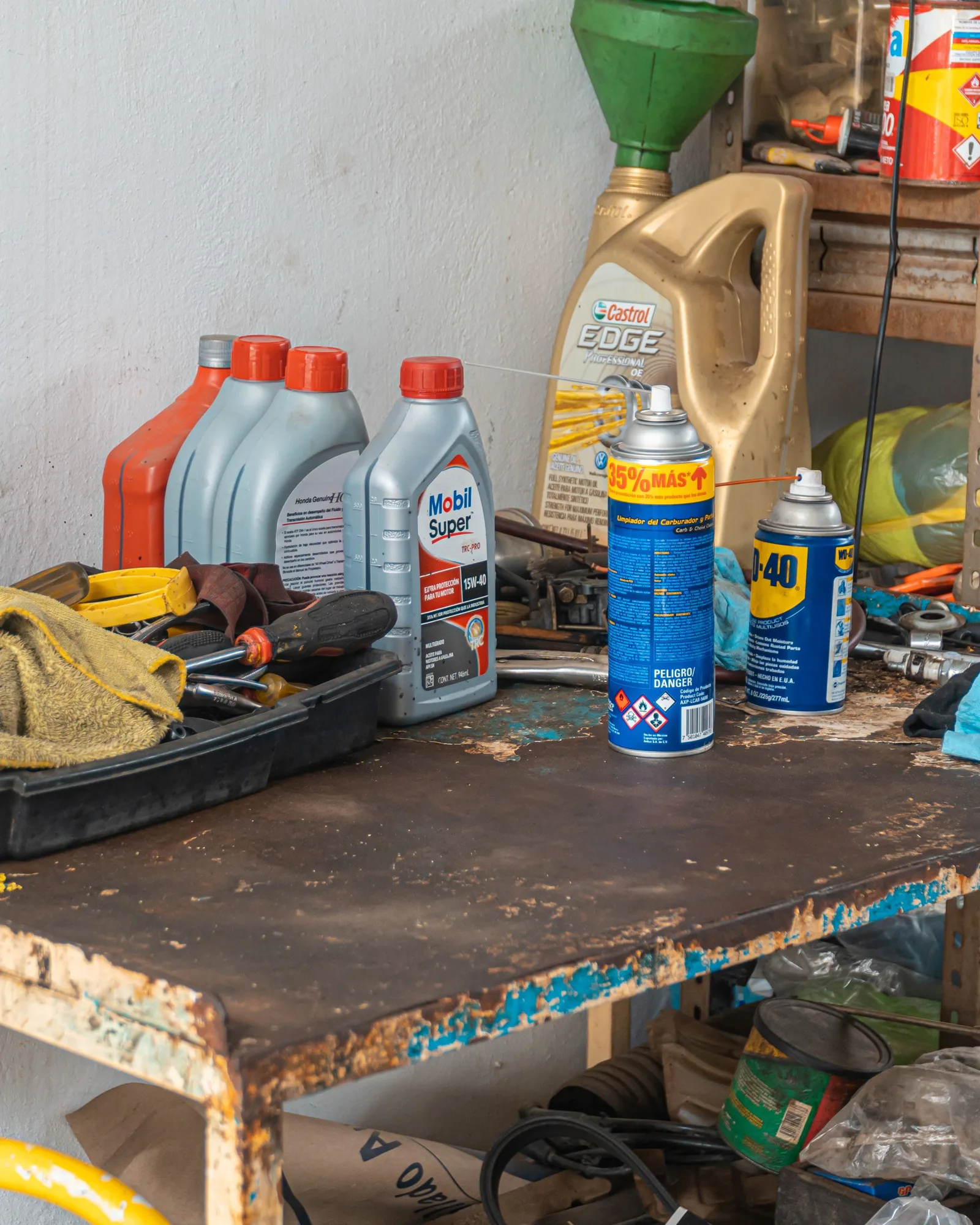 Établi d’atelier avec bidons d’huile, aérosols et chiffons
